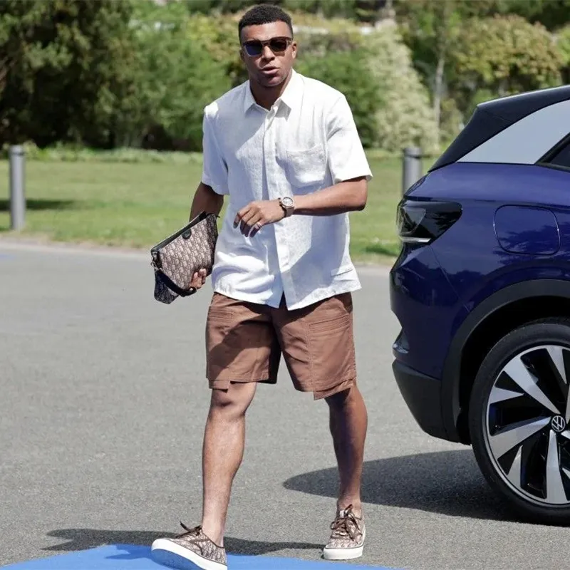 Kylian Mbappé est arrivé à Clairefontaine avec une tenue parfaite : chemisette, bermuda, sneakers d'été…