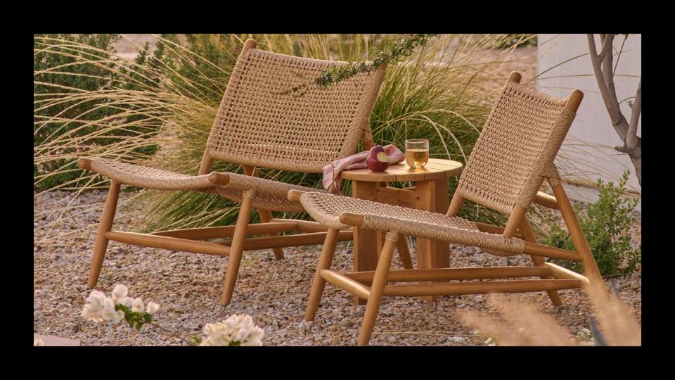 Two of Hati Home's Bali Lounge Chairs sitting side by side on a rock patio.