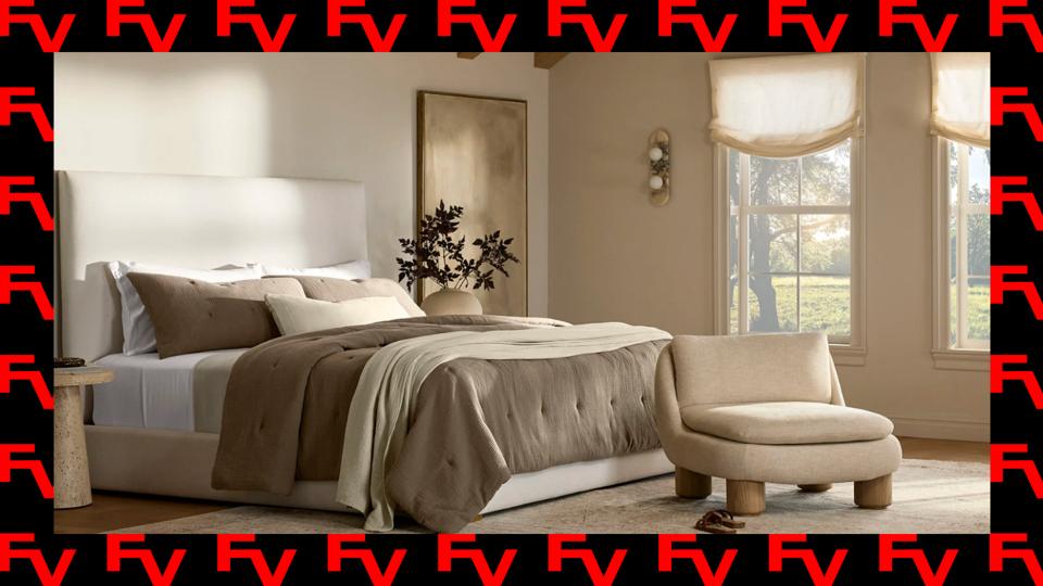 A neatly made bed with Boll & Branch bedding in a modern bedroom.